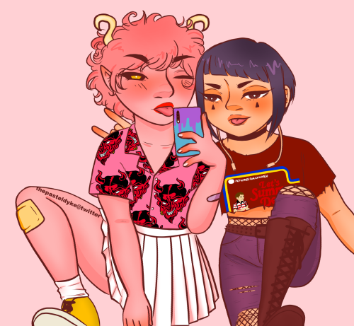 Mina and Jiro taking a mirror selfie, both have a leg up at the edge of the picture so that one leg is fully visible, the other ending mid thigh. Mina is holding a phone between them, her other hand down. Jiro has ne arm reaching out to the side, the other behind Mina flashing the sign of the horns. Mina is wearing a pink short sleeved button up shirt with red oni masks on it, tucked into a white pleated short skirt. She's wearing yellow converse and white socks. She has a yellow plaster on her knee. Jiro is wearing a t-shirt that has been cut off to become a crop top, edges of the collar and sleeves cut off so they're fraying. The t-shirt reads 'let's summon demons', darkblue jeans with torn knees. She's wearing high waisted fishnets underneath as well as knee high dark boots. They're both sticking their tongues out, Mina is winking. The background is a solid pale pink.