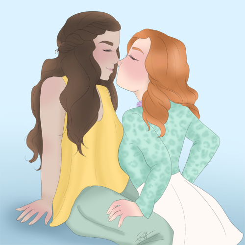 Cassandra and Estrella from The Librarians, about to kiss. Cassandra is standing between Estrella's legs, hands on her thighs. Estrella is propped up on her arms. Both their eyes are closed. Estrella is wearing a yellow topp and green trousers. Cassandra is wearing a gren top with leopard print and a white skirt.