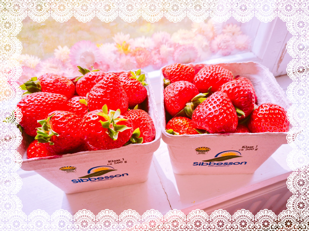 Two cardboard boxes of strawberries on a window sill.